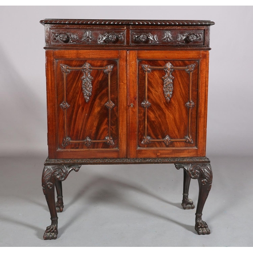 383 - A MAHOGANY CABINET, c1900, having a gadroon rim above two drawers with applied foliate scroll work a... 