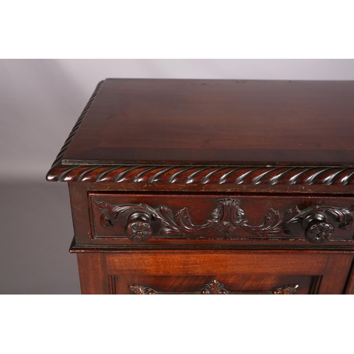 383 - A MAHOGANY CABINET, c1900, having a gadroon rim above two drawers with applied foliate scroll work a... 