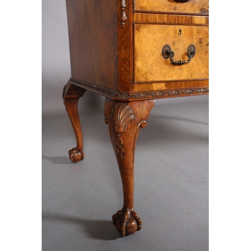 385 - AN 18TH CENTURY-STYLE FIGURED WALNUT DESK, inverted breakfront, having three incised leather panels,... 