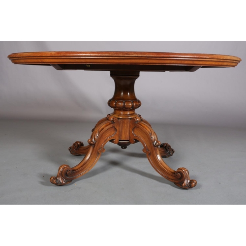 414 - A VICTORIAN FIGURED WALNUT LOOE TABLE, oval, having a quarter veneer tilt top, on a turned and beade... 