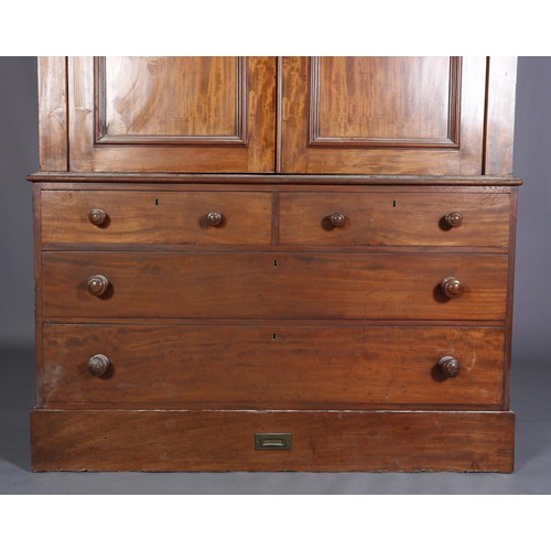 407 - A 19TH CENTURY MAHOGANY CLOTHES PRESS, having a moulded cornice above two indented panel doors, the ... 