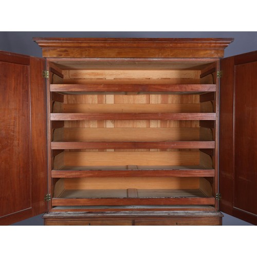 407 - A 19TH CENTURY MAHOGANY CLOTHES PRESS, having a moulded cornice above two indented panel doors, the ... 