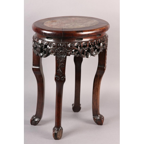 114 - A 19TH CENTURY CHINESE HARDWOOD AND MARBLE INSET URN STAND OF OVAL OUTLINE, the apron pierced and ca... 