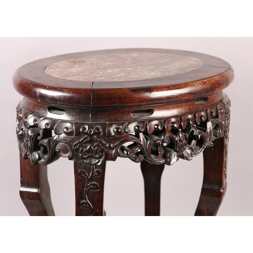 114 - A 19TH CENTURY CHINESE HARDWOOD AND MARBLE INSET URN STAND OF OVAL OUTLINE, the apron pierced and ca... 