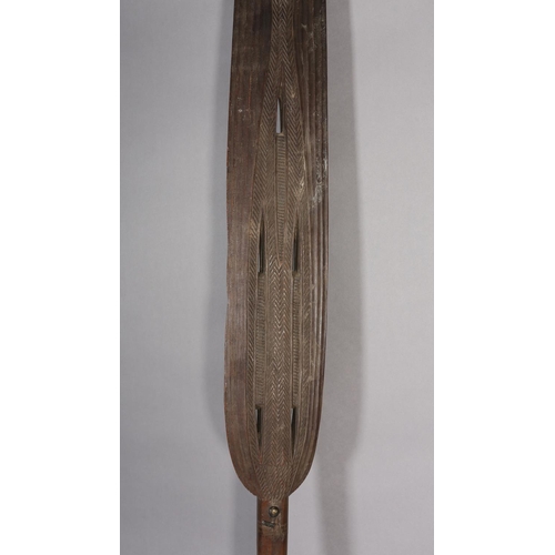 16 - A TRIBAL PADDLE with carved and pierced decoration, 181cm