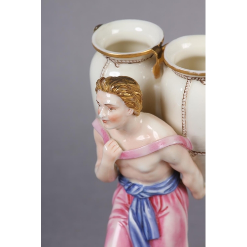 87 - A ROYAL WORCESTER FIGURE OF A CLASSICAL MALE WATER CARRIER, carrying two amphora vases on his back, ... 