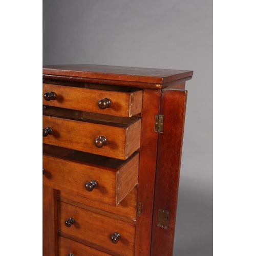 372 - A MID 19TH CENTURY MAHOGANY WELLINGTON CHEST of seven graduated drawers with turned handles, foliate... 