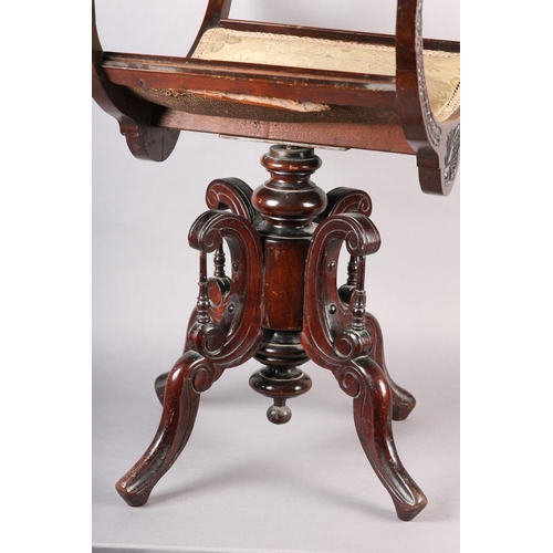 402 - A LATE 19TH CENTURY MAHOGANY REVOLVING PIANO STOOL, the dished seat with open curved upright arms, t... 