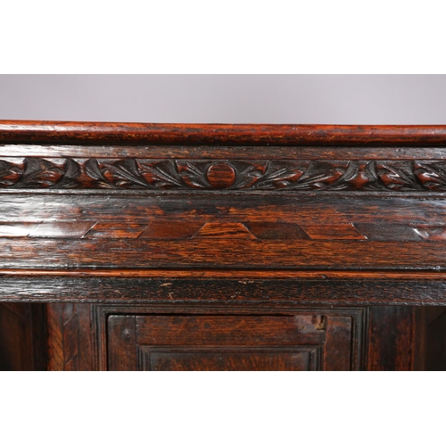 358 - A 17TH CENTURY JOINED OAK COURT CUPBOARD, having a foliate carved cornice, the frieze inlaid in ebon... 