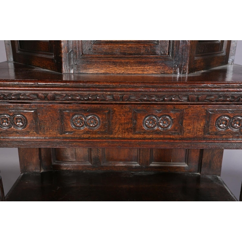 358 - A 17TH CENTURY JOINED OAK COURT CUPBOARD, having a foliate carved cornice, the frieze inlaid in ebon... 