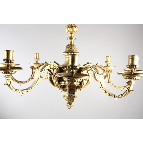 36 - A GILT METAL EIGHT LIGHT chandelier, the central baluster stem cast with scrolls and lion masks issu... 