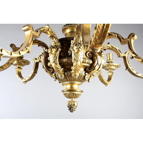 36 - A GILT METAL EIGHT LIGHT chandelier, the central baluster stem cast with scrolls and lion masks issu... 