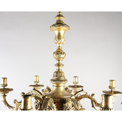 36 - A GILT METAL EIGHT LIGHT chandelier, the central baluster stem cast with scrolls and lion masks issu... 