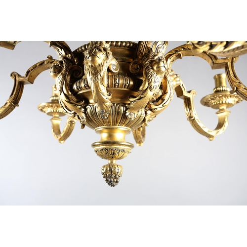 36 - A GILT METAL EIGHT LIGHT chandelier, the central baluster stem cast with scrolls and lion masks issu... 