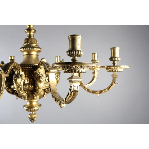 36 - A GILT METAL EIGHT LIGHT chandelier, the central baluster stem cast with scrolls and lion masks issu... 