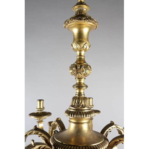 36 - A GILT METAL EIGHT LIGHT chandelier, the central baluster stem cast with scrolls and lion masks issu... 