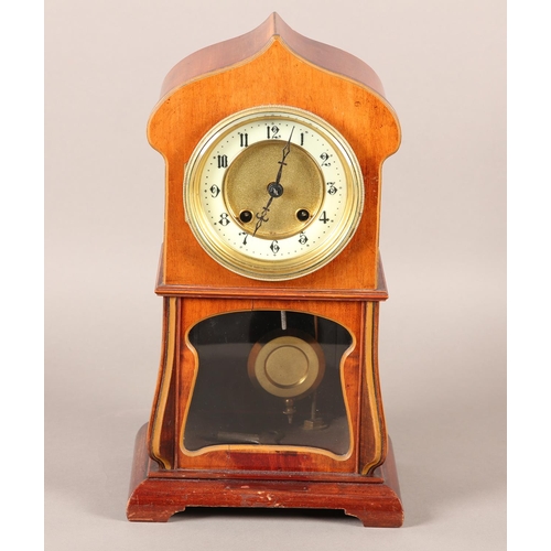 50 - AN ART NOUVEAU MAHOGANY AND GLAZED MANTEL CLOCK of arched outline, having a two part dial, black Ara... 