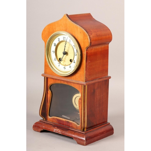 50 - AN ART NOUVEAU MAHOGANY AND GLAZED MANTEL CLOCK of arched outline, having a two part dial, black Ara... 