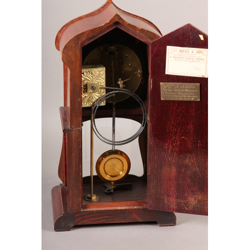 50 - AN ART NOUVEAU MAHOGANY AND GLAZED MANTEL CLOCK of arched outline, having a two part dial, black Ara... 