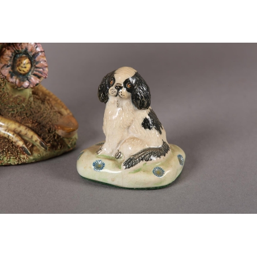 82 - A BASIL MATTHEW POTTERY MODEL OF A SPANIEL, sitting on a green and gilt cushion, 8cm high and anothe... 