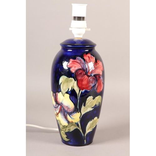 91 - A MOORCROFT LAMP, of baluster form, painted with yellow and purple hibiscus blooms and foliage, 35cm... 