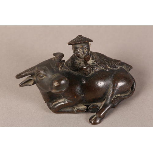 128 - A 19TH CENTURY CHINESE BRONZE GROUP OF A BOY LYING ON THE BACK OF A RECUMBENT WATER BUFFALO, 11cm wi... 