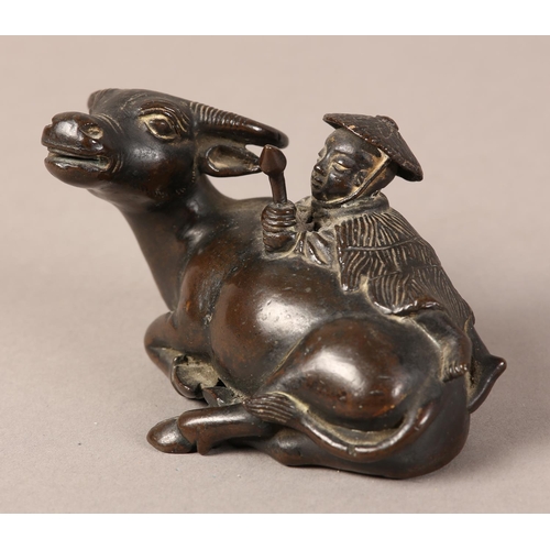 128 - A 19TH CENTURY CHINESE BRONZE GROUP OF A BOY LYING ON THE BACK OF A RECUMBENT WATER BUFFALO, 11cm wi... 