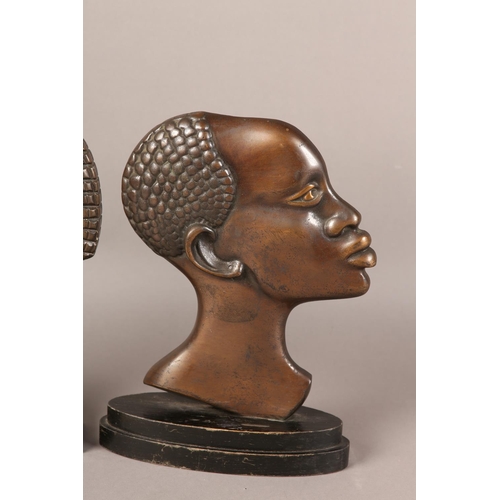 57 - TWO EARLY 20TH CENTURY BRONZE PROFILES OF AN AFRICAN TRIBESMAN AND WOMAN, after Hagenau, coppered pa... 