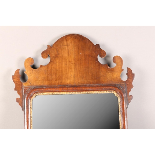 406 - A MID 18TH CENTURY WALNUT WALL MIRROR having a fret-cut frame, rectangular glass with parcel gilt sl... 