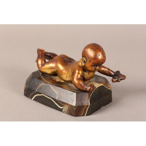 11 - A gilded bronze figure of an infant lying on it's stomach, on an agate base, 14.5cm long x 9.5cm hig... 