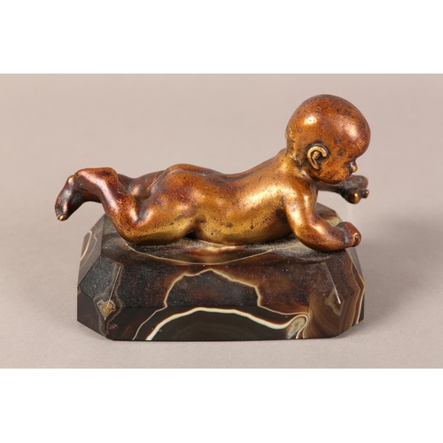 11 - A gilded bronze figure of an infant lying on it's stomach, on an agate base, 14.5cm long x 9.5cm hig... 