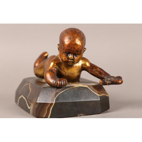 11 - A gilded bronze figure of an infant lying on it's stomach, on an agate base, 14.5cm long x 9.5cm hig... 