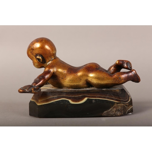 11 - A gilded bronze figure of an infant lying on it's stomach, on an agate base, 14.5cm long x 9.5cm hig... 