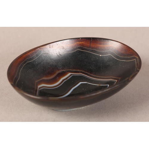 18 - A banded agate bowl of oval outline on foot rim, 9cm wide x 6.5cm deep x 2.75cm high (two cracks to ... 