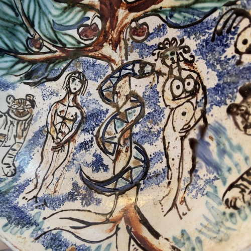 58 - A 20th century earthenware dish painted with the Garden of Eden, with Adam and Eve, the apple tree a... 