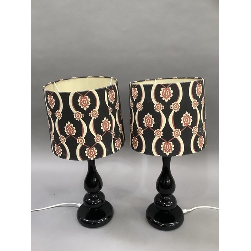 420 - A pair of black perspex moulded retro style lamps having black, cream and red shades, 35cm high