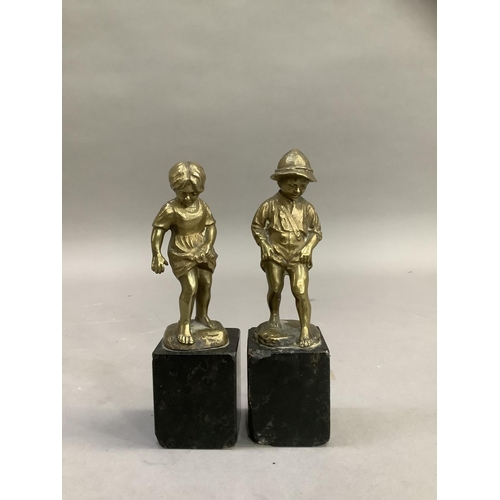 61 - After Perot, a pair of 19th century brass sculptures of a boy and girl paddling raised on black marb... 