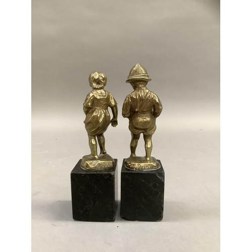 61 - After Perot, a pair of 19th century brass sculptures of a boy and girl paddling raised on black marb... 