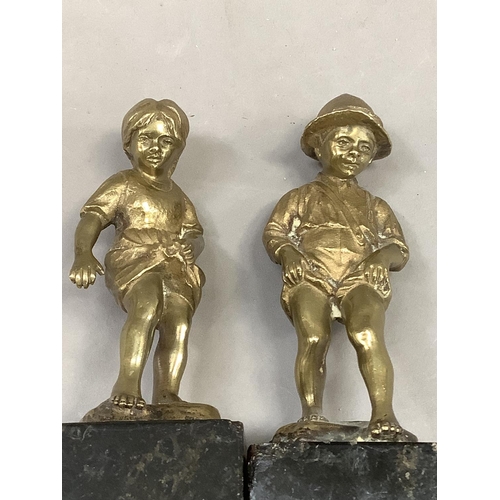 61 - After Perot, a pair of 19th century brass sculptures of a boy and girl paddling raised on black marb... 