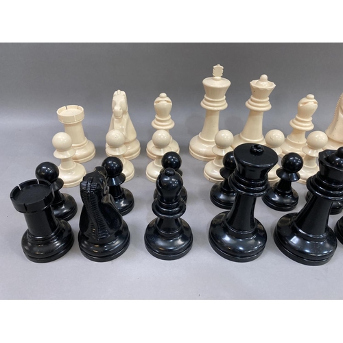 114 - A outdoors chess set in cream and black plastic, the king measuring 21cm high