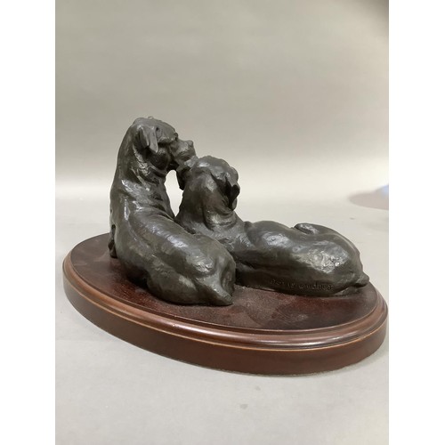 74 - A bronze effect group of two boxer dogs on an oval plinth, 30cm wide x 15cm high