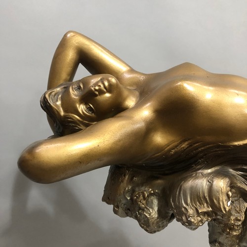 1 - An Art Deco gilded plaster table lamp modelled as a nude female reclining on the crest of a wave abo... 