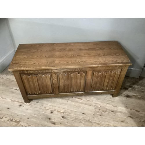 421 - An oak ottoman with linen fold front and on stile feet