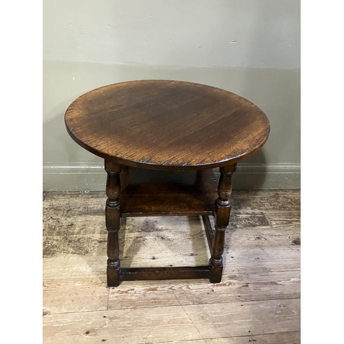 433 - A Titchmarsh and Goodwin oak occasional table, circular outline on turned legs joined by a square un... 