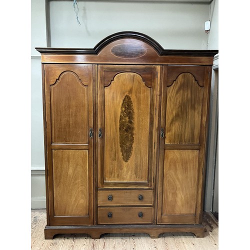 434 - An Edwardian three door wardrobe of semi arched profile with moulded cornice, the middle door having... 