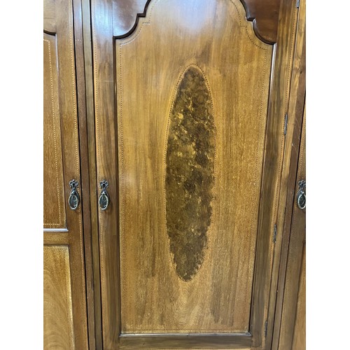 434 - An Edwardian three door wardrobe of semi arched profile with moulded cornice, the middle door having... 