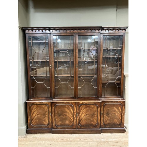 440 - A mahogany breakfront bookcase having a  moulded and dentil cornice above four tracery glazed doors,... 