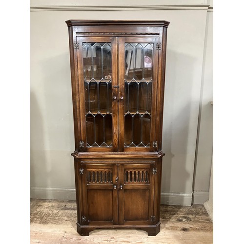 446 - A Reprodux standing corner cupboard having a moulded cornice above leaded glazed two door cupboard a... 