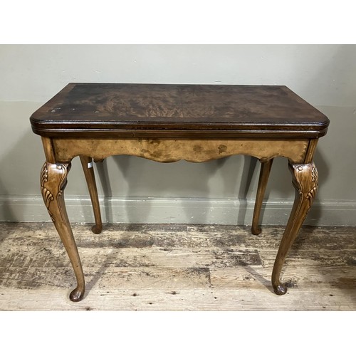 448 - An 18th century style walnut fold over card table with shaped apron and on slender cabriole legs car... 