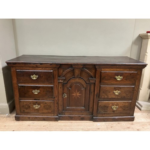 458 - A oak dresser base having an inverted breakfront arched door cupboard inlaid with star paterae to th... 